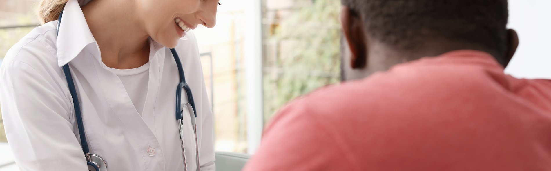 Individuelle Behandlung und Services Eine Ärztin ist im Gespräch mit einem ausländischen Patienten zur medizinischen Behandlung.